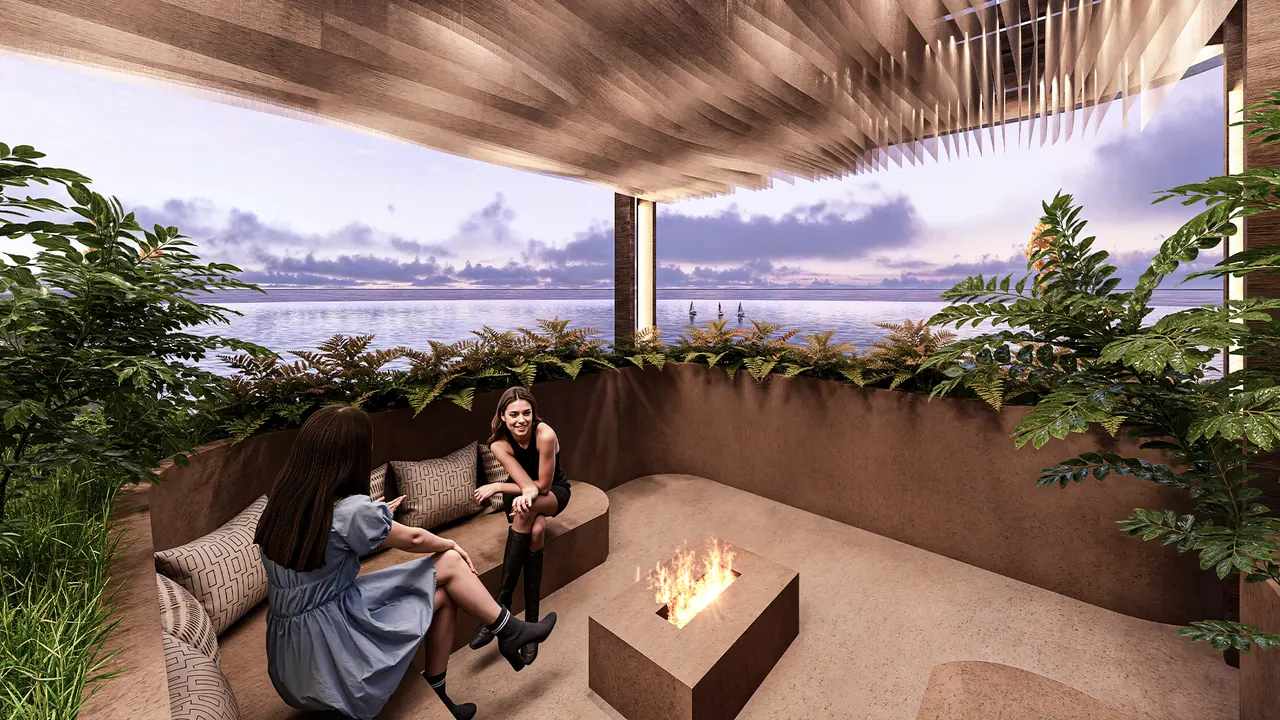 The rooftop lounge at sunset with a fire and the sea beyond